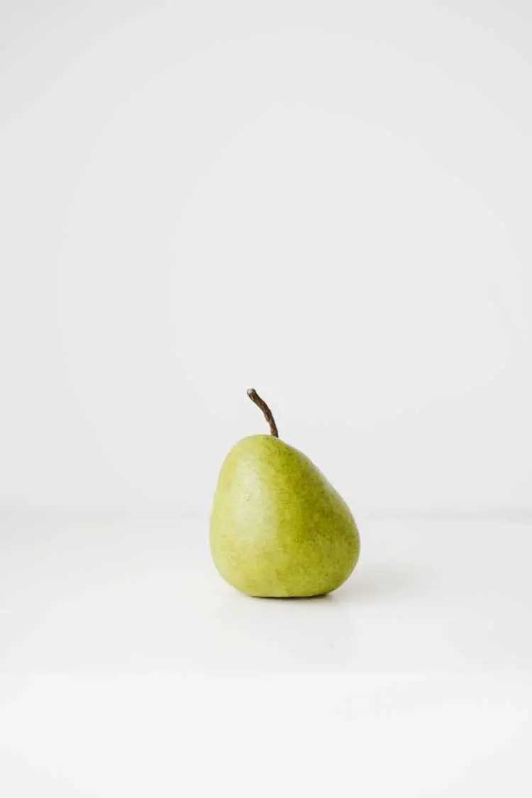 Fresh healthy pear on white surface